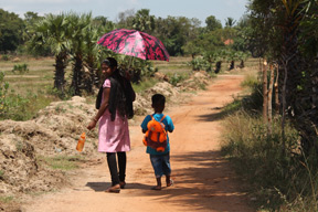Child being walked to school in Sri Lanka
